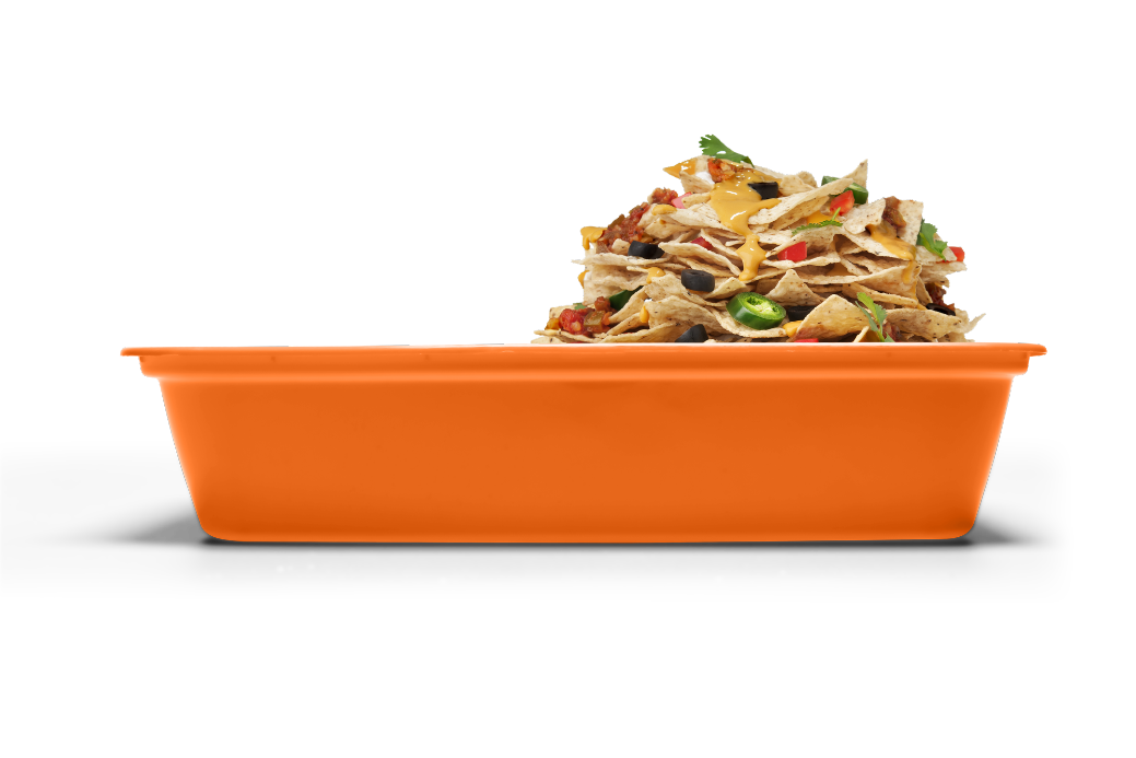 A large pile of nachos with various toppings is served in an orange rectangular dish against a white background.