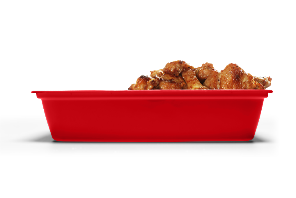 A red rectangular container filled with pieces of cooked, seasoned chicken.