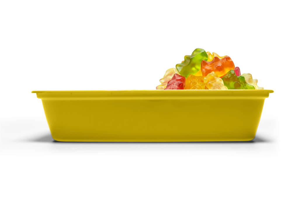 A yellow rectangular tray containing assorted colorful gummy bears, viewed from the side on a white background.